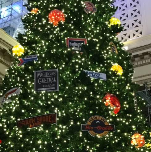 Credit: S.M. O'Connor Caption: This Christmas tree in the Great Hall of Union Station in downtown Chicago has emblems of Amtrak, Metra, and historic railroad companies whose routes they now operate like Burlington.